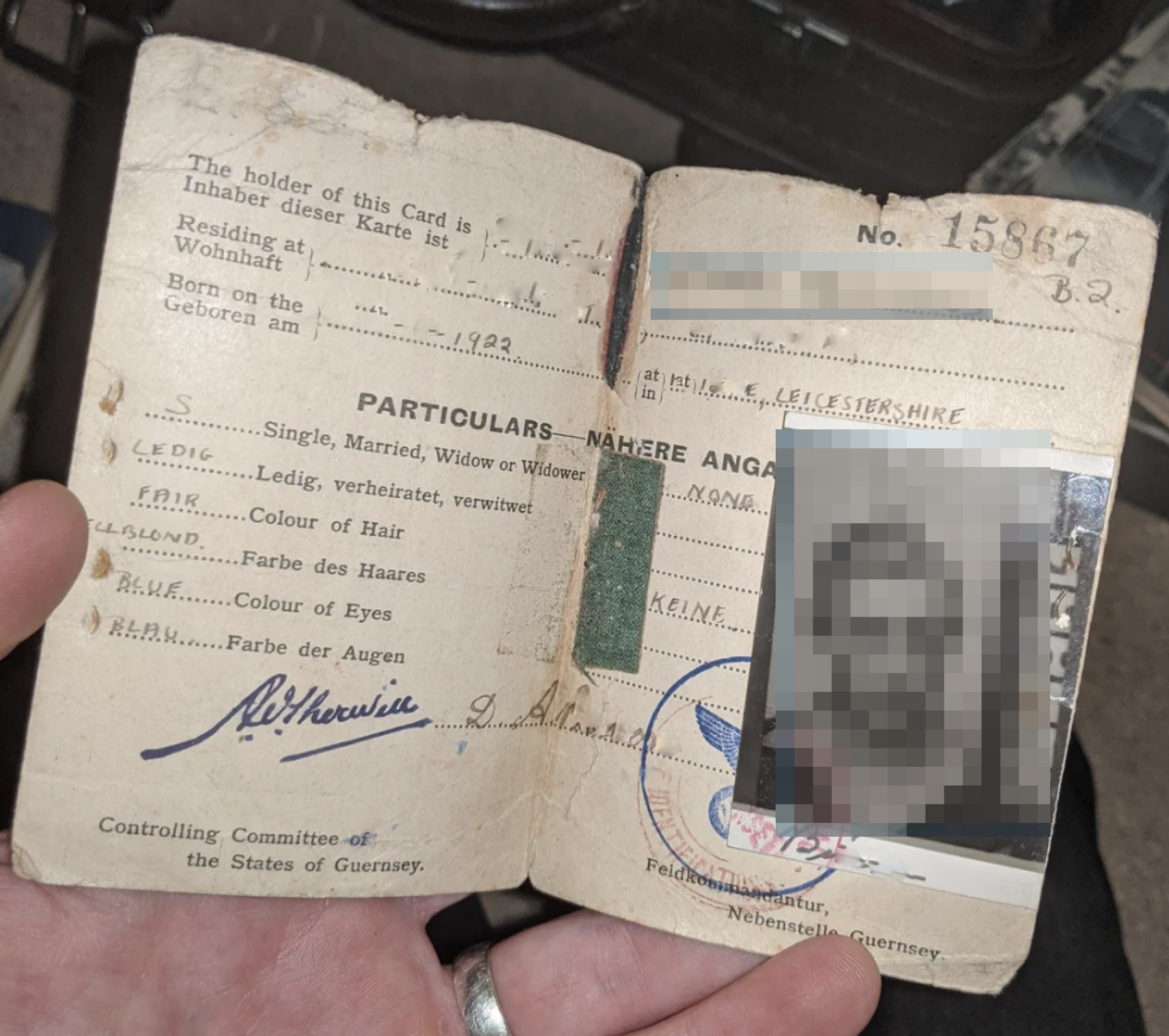 Open identification document showing a photo of a man, along with personal details such as birth date, marital status, and hair and eye color