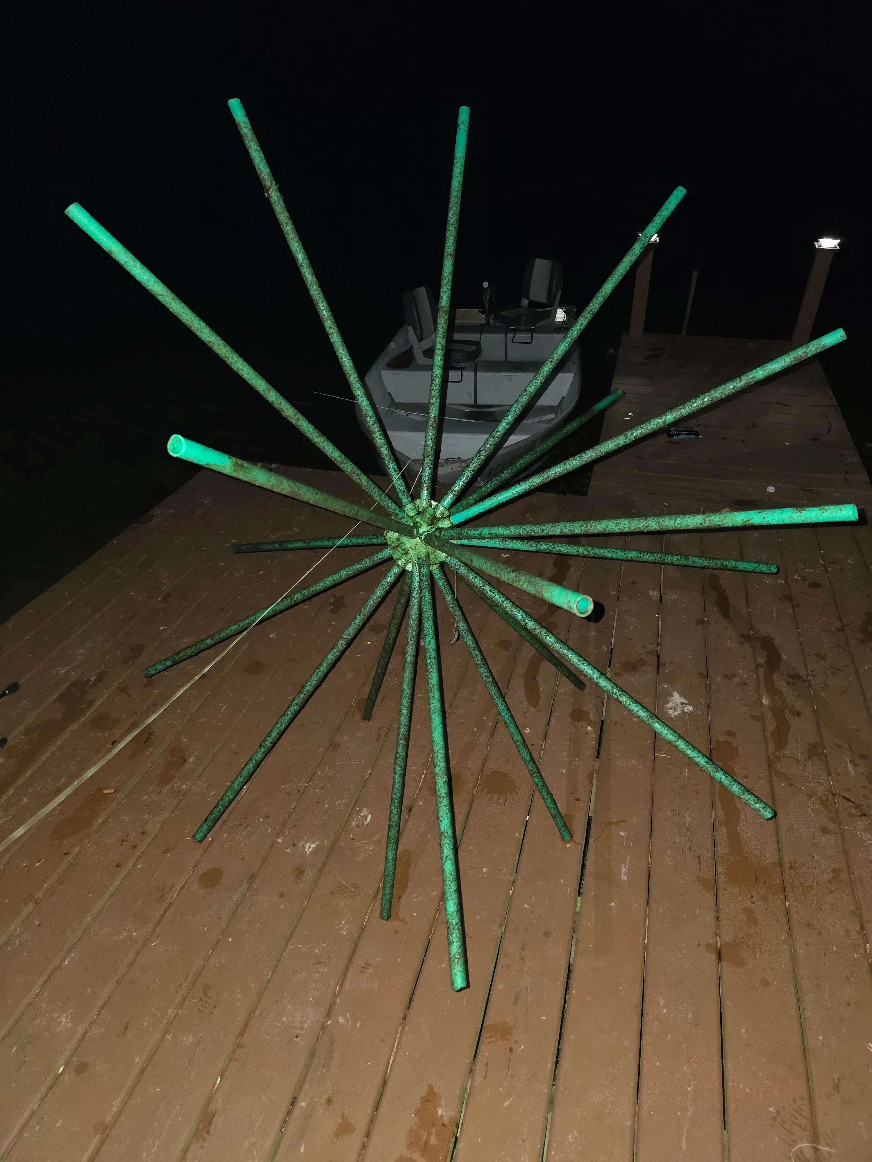 A metal structure with many rods protruding from a central point stands on the dock