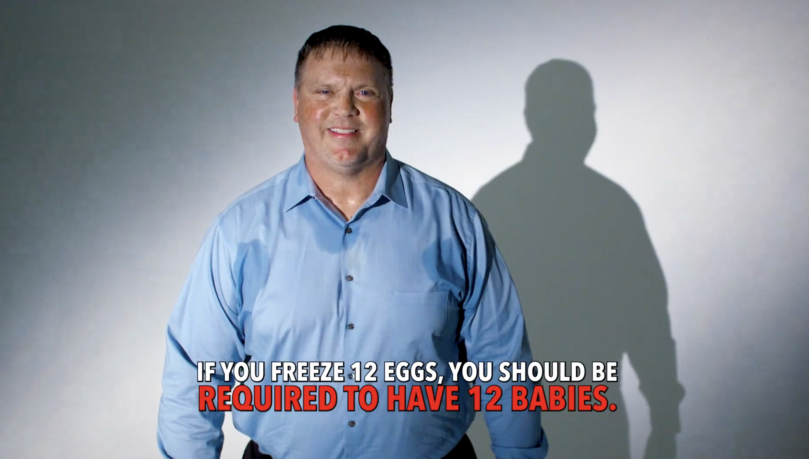A man in a blue shirt stands in front of a white background with a shadow behind him. Text reads, "If you freeze 12 eggs, you should be required to have 12 babies."
