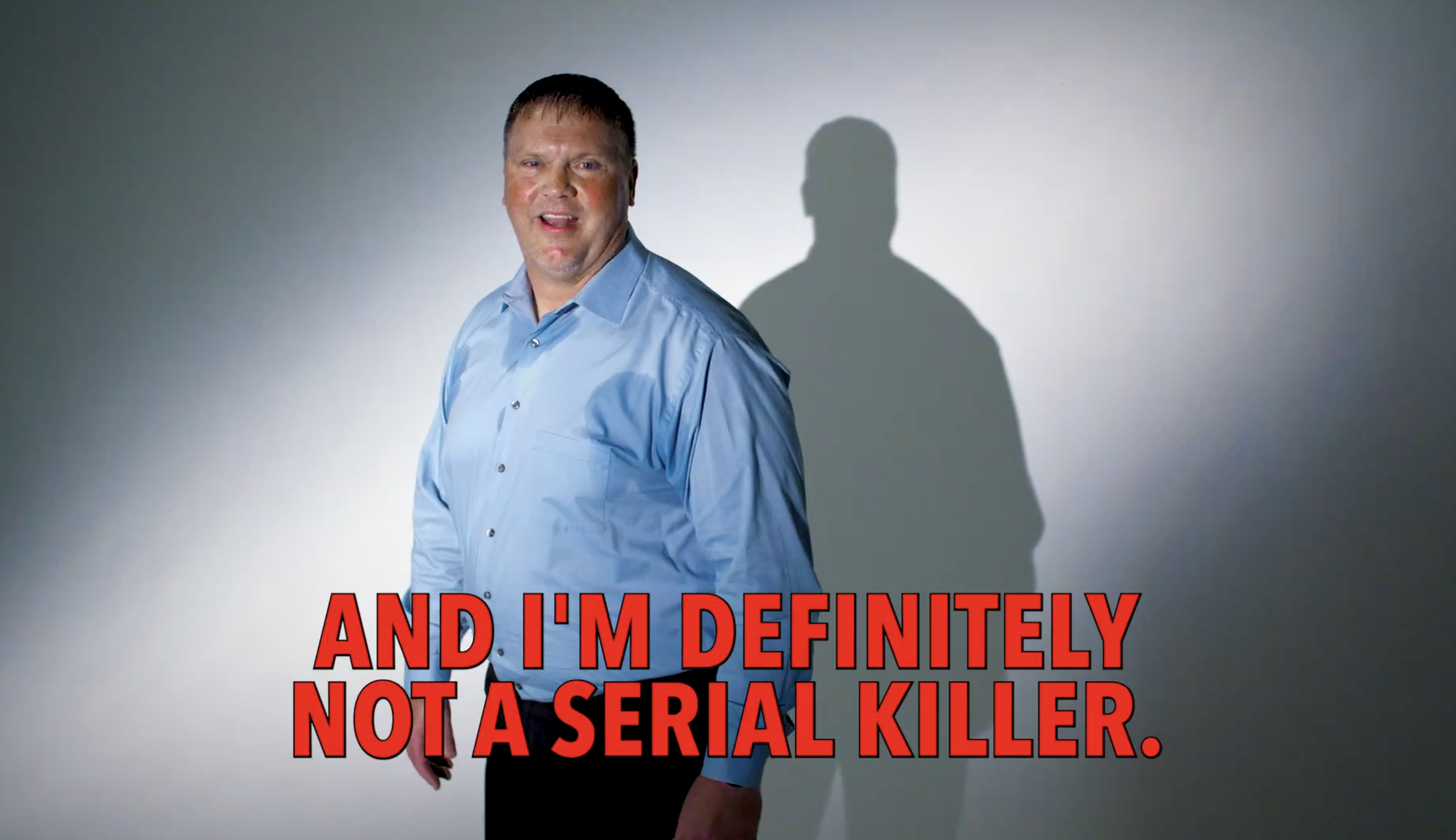 A man in a light shirt smiles against a white background with text overlay stating, "AND I'M DEFINITELY NOT A SERIAL KILLER."
