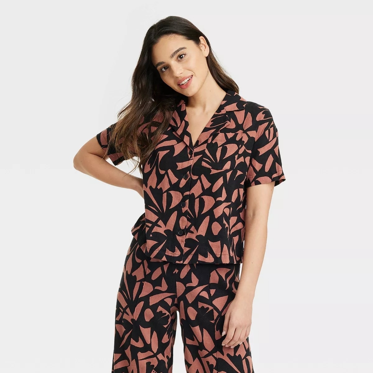 A model wearing a linen camp shirt with matching pants