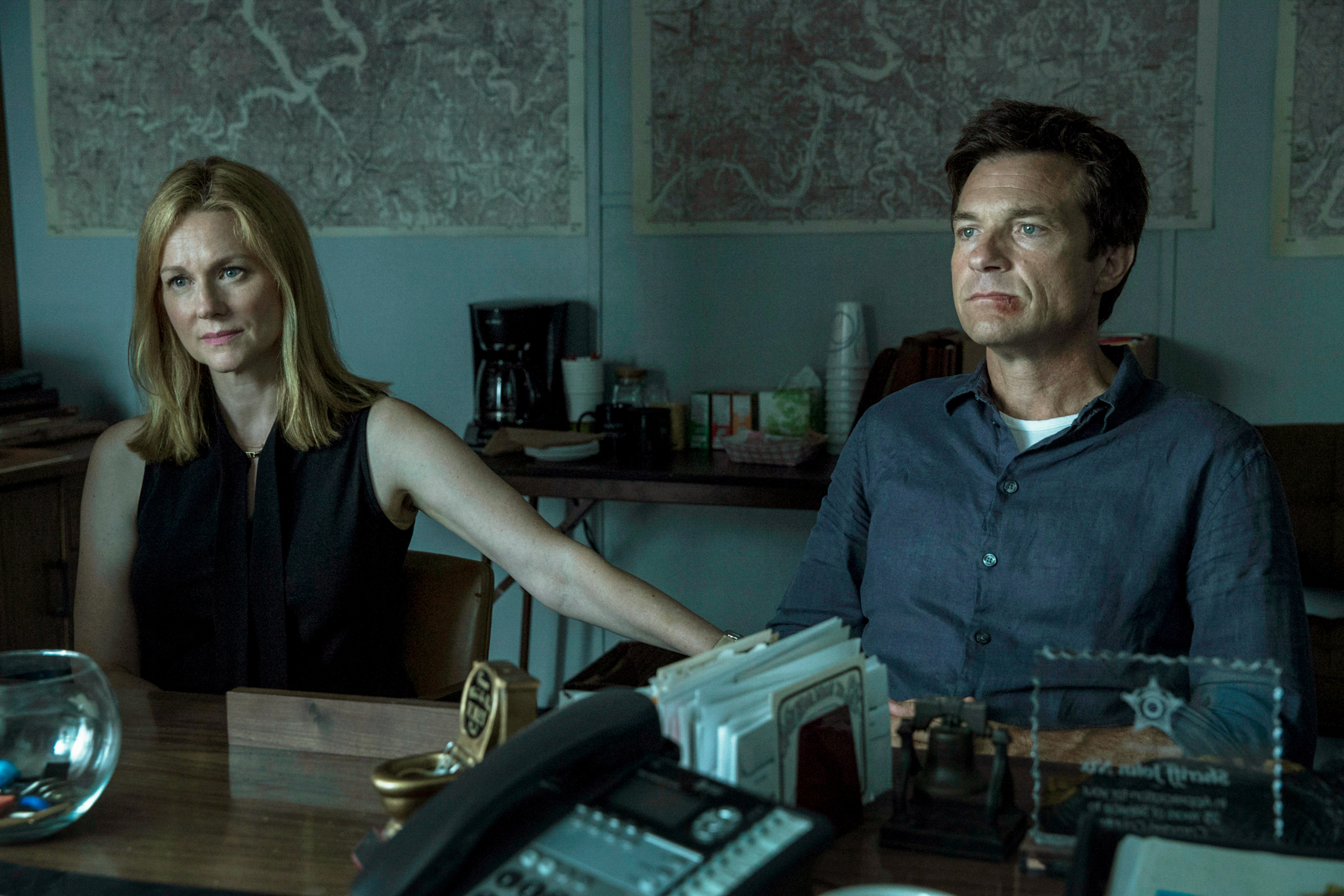 Jason Bateman and Laura Linney looking serious in front of an office desk in a scene from "Ozark"