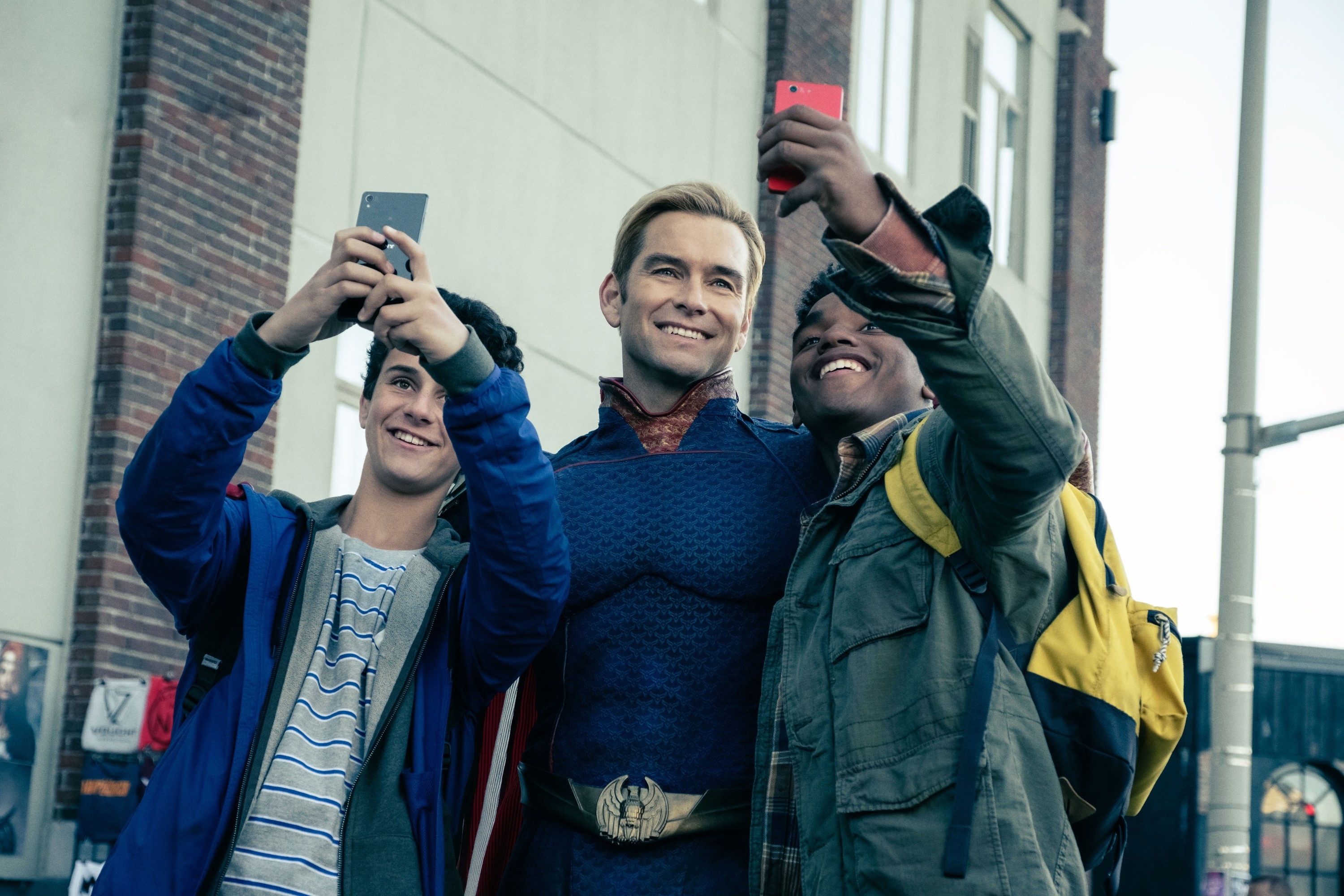 Antony Starr posing for selfies with fans in a scene from "The Boys"