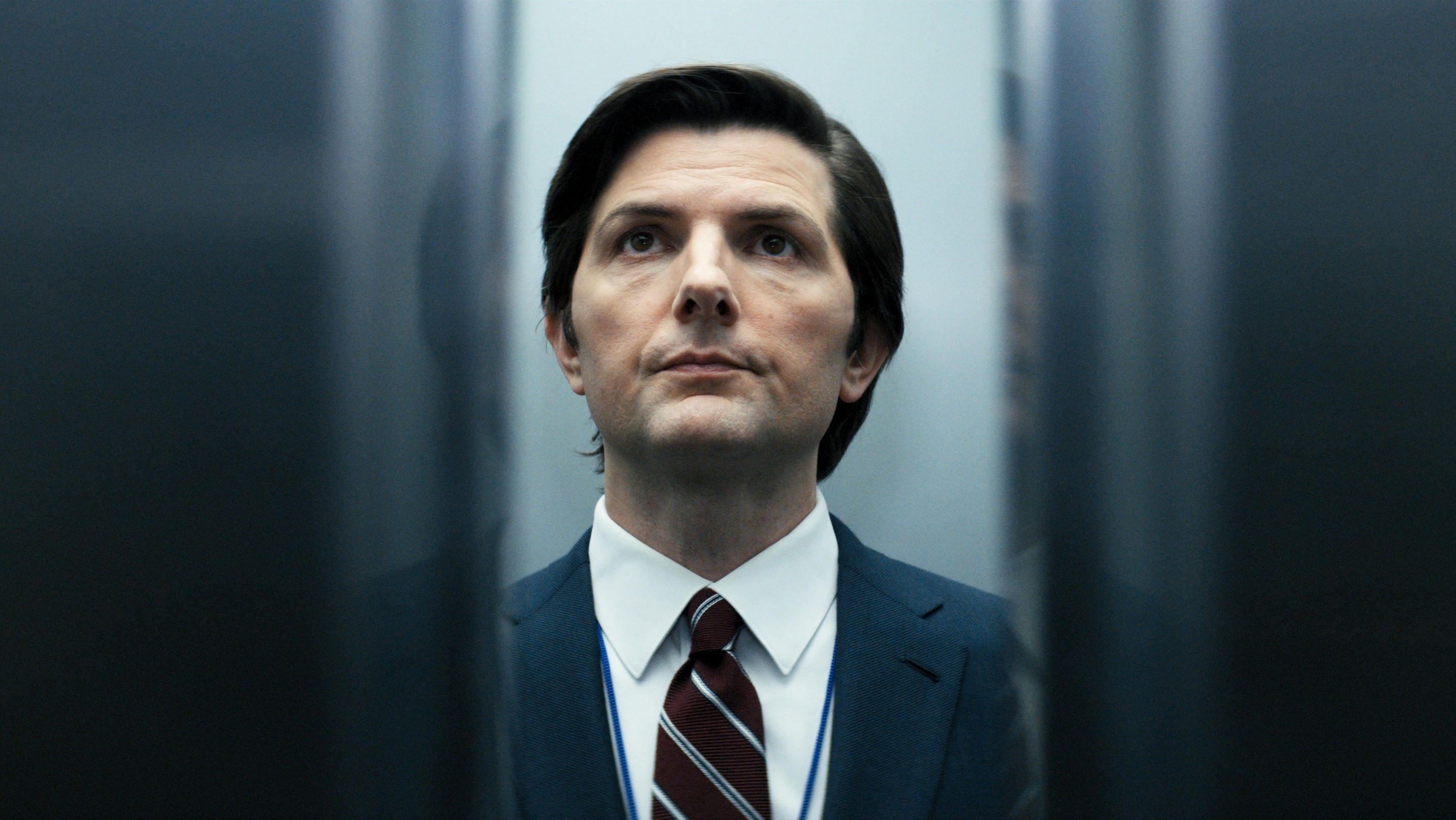 Adam Scott standing in an elevator in a scene from "Severance"