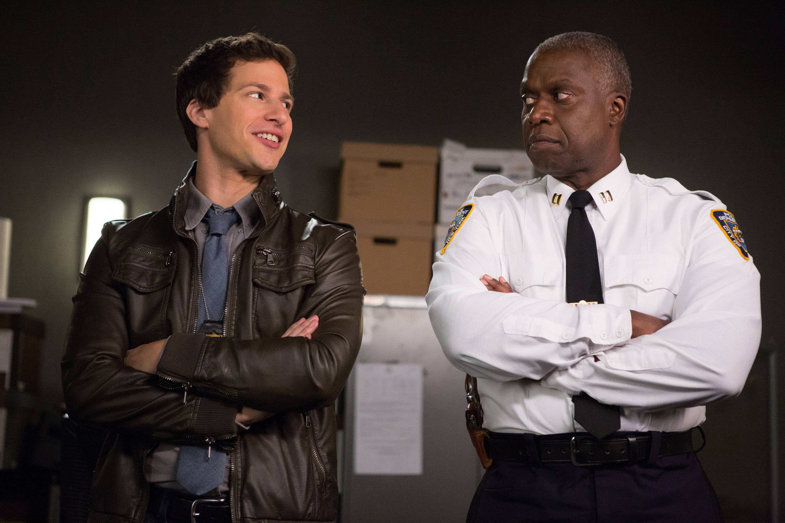 Andy Samberg and Andre Braugher looking at each other while crossing their arms in a scene from "Brooklyn Nine-Nine"