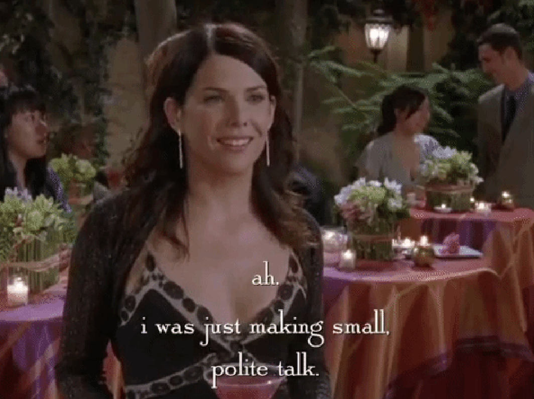 Lauren Graham, in a patterned dress and long earrings, stands at an event with tables decorated with flowers and candles, captioned &quot;ah. i was just making small, polite talk.&quot;