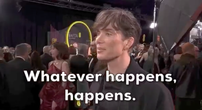 Cillian Murphy at a red carpet event, interviewed with the text overlay &quot;Whatever happens, happens.&quot;
