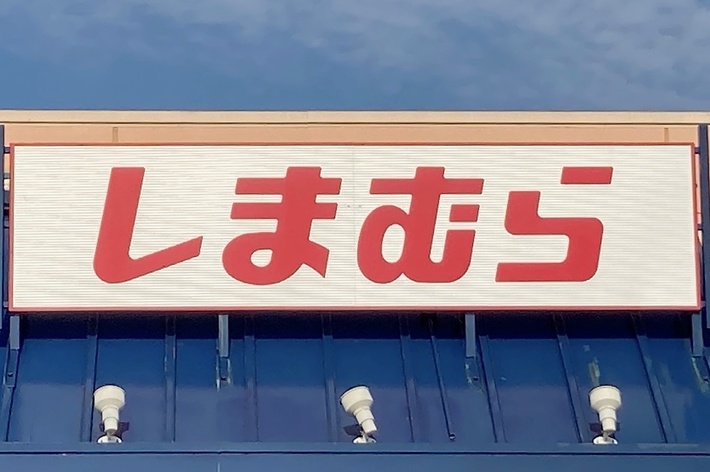 The image shows the storefront of a Shimamura retail store, with its sign written in Japanese characters