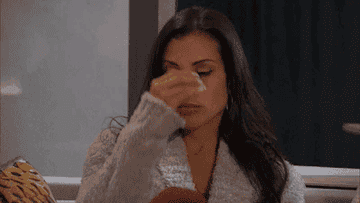 A woman is seen pinching the bridge of her nose in frustration. This image is used in an article categorized under Internet Finds