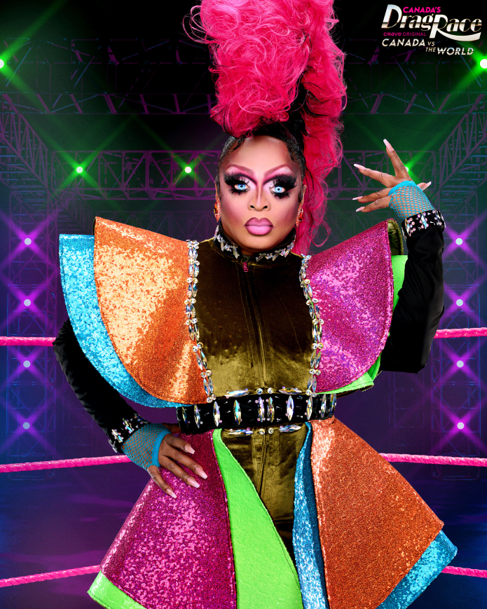 Priyanka in bold, colorful sequin outfit with a dramatic pink headdress, posing in front of the "Canada's Drag Race: Canada vs The World" stage背景。
