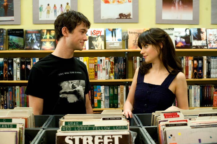 Joseph Gordon-Levitt and Zooey Deschanel looking at each other in a record store in (500) Days of Summer