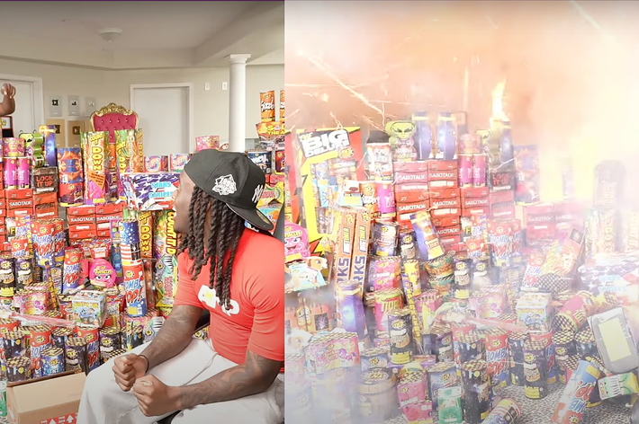 Several people are in a room filled with fireworks, with one man setting them off, causing an explosion of light and smoke. Only the back of one person is visible
