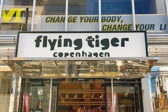 フライングタイガー コペンハーゲンの店舗入口。背景に「CHANGE YOUR BODY, CHANGE YOUR LIFE」の看板がある。