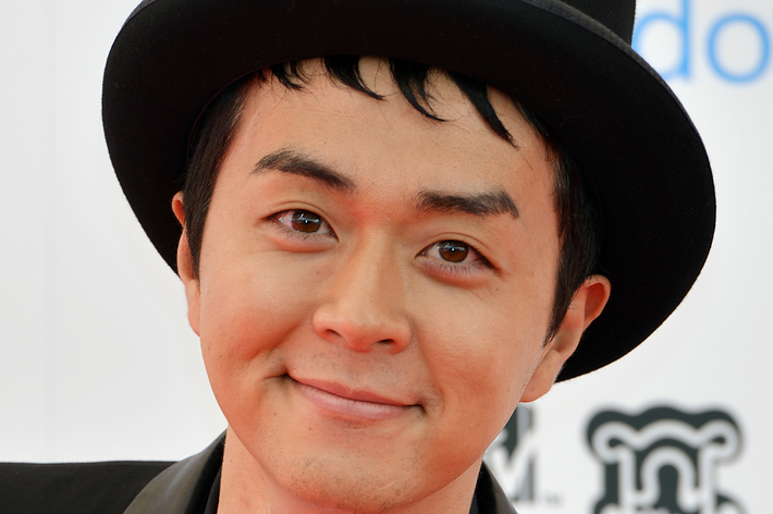 黒木啓司、黒いスーツとシルクハット、白い蝶ネクタイを身に着け、赤いカーペットに登場。