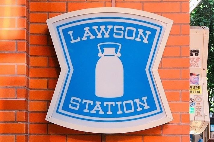 ローソンの看板には「LAWSON STATION」と「OPEN 24 HOURS」と書かれています。
