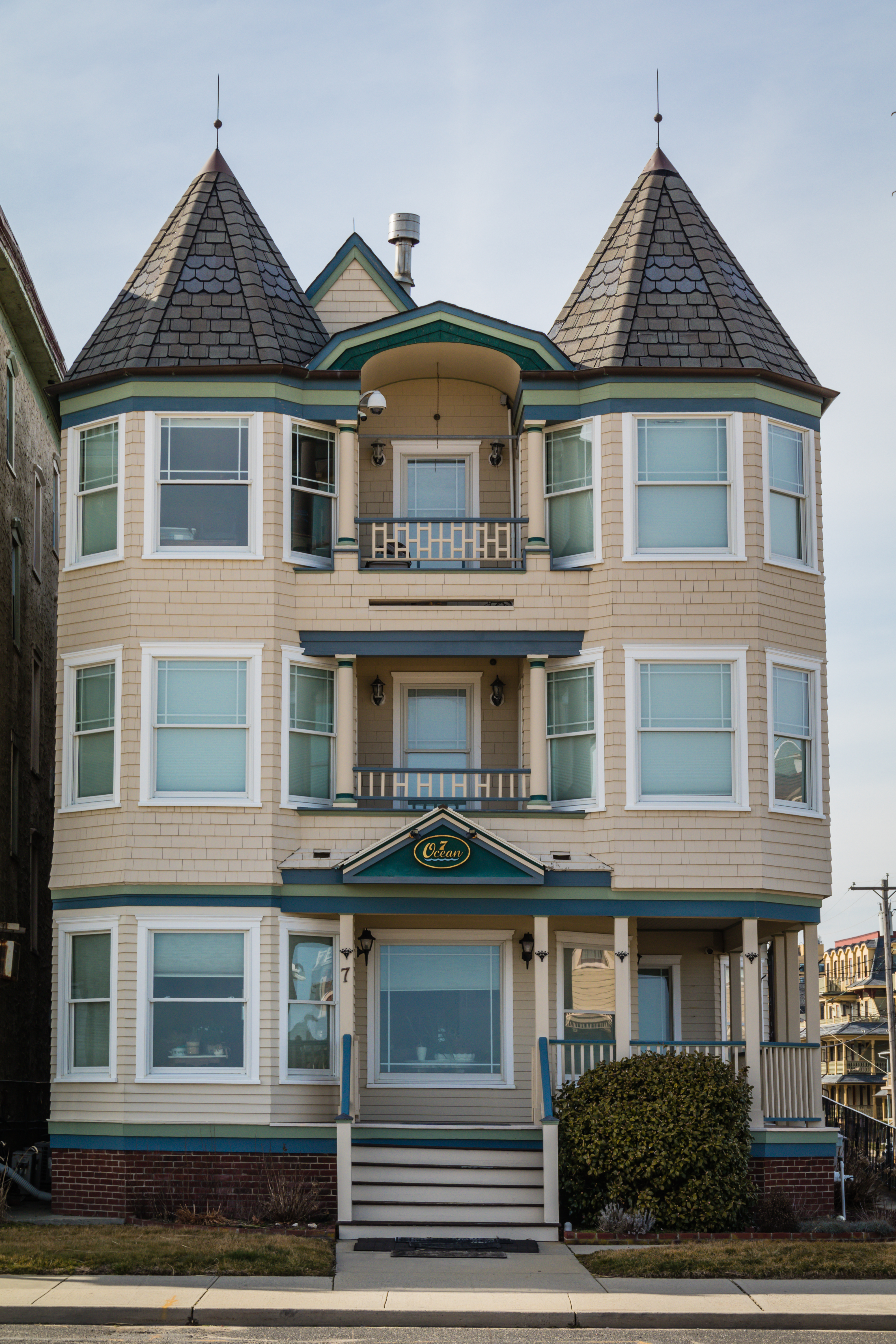 A three-story, Victorian-style house with two towers and a sign that reads "Elan" above the front entrance. The house has bay windows and a small balcony