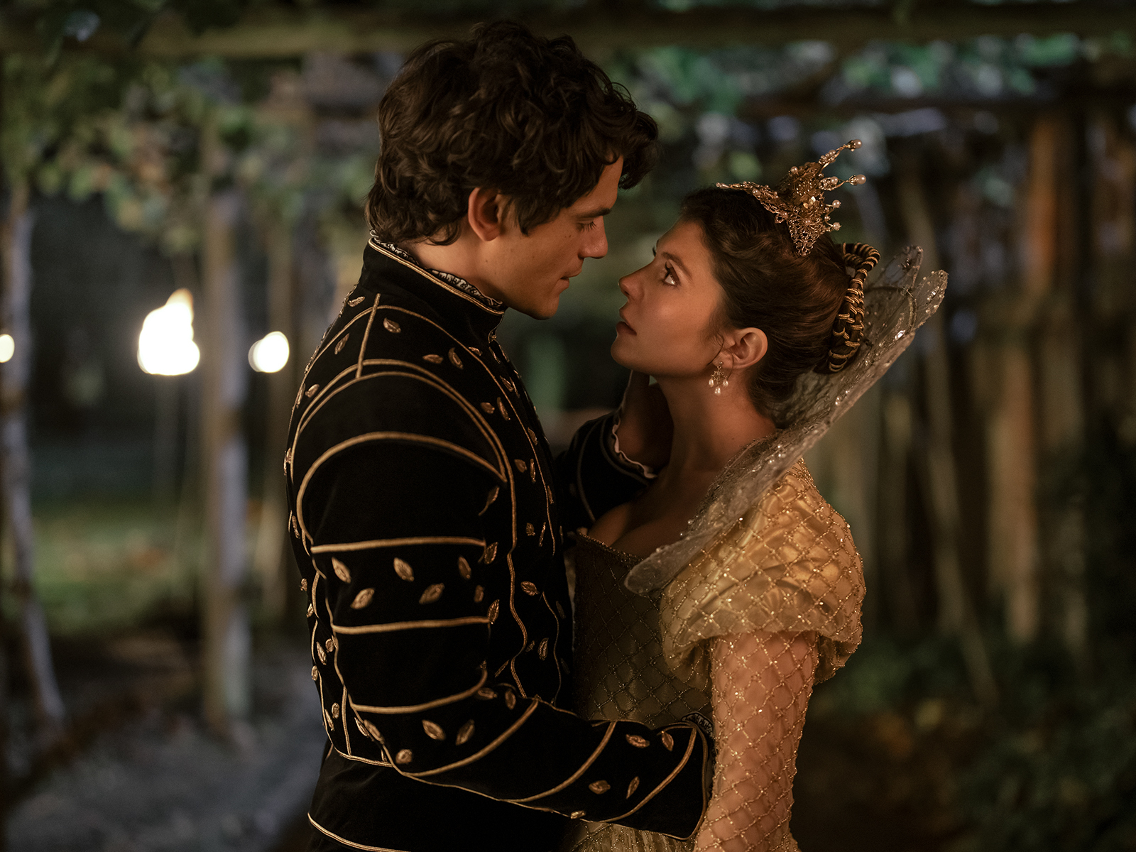 Ambrose y Sabrina, personajes de "Las escalofriantes aventuras de Sabrina", se miran fijamente bajo un cenador. Ambos llevan trajes de época elegantes