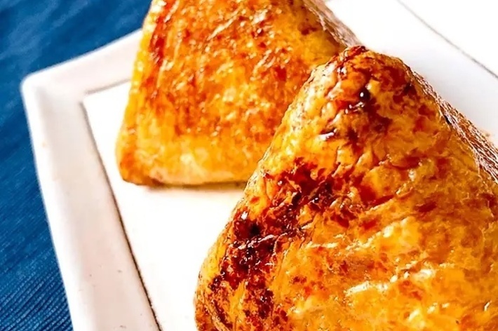 白いプレートに盛られた美味しそうな焼きおにぎりが二つあります。