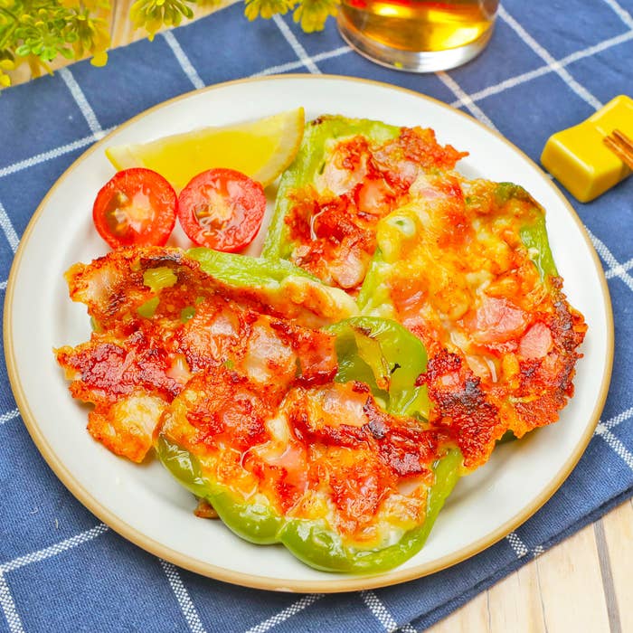 焼かれたピーマンにトマトとチーズがトッピングされた料理が皿に盛られている。