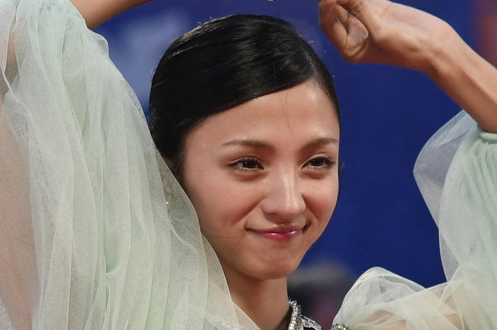 女優がレッドカーペットで、大きなふんわりした袖と黒い猫のデザインが施されたドレスを着てポーズをとっています。