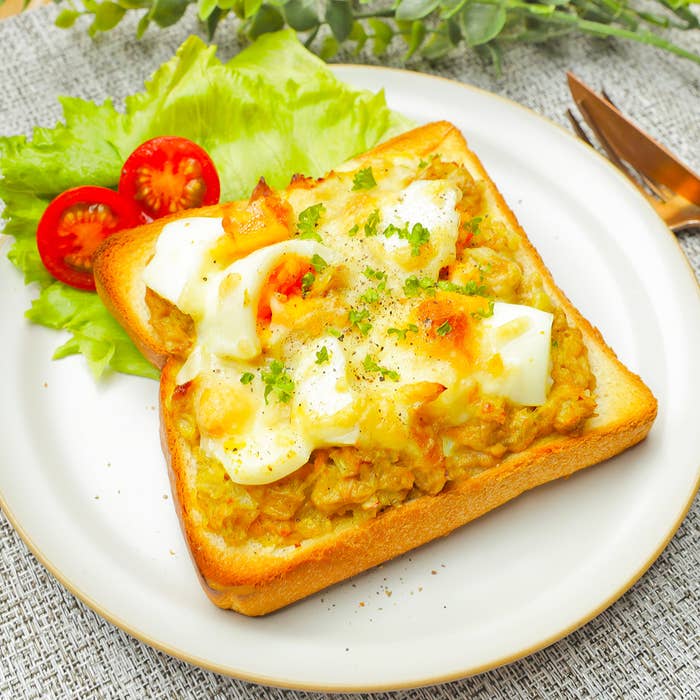 お皿に盛られたトーストとレタス、ミニトマトのサラダがあります。