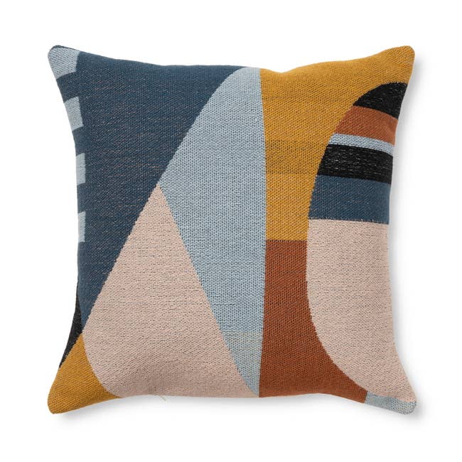 A decorative propulsion pillow with a minimalist abstract geometric design, featuring shapes successful assorted neutral and world tones