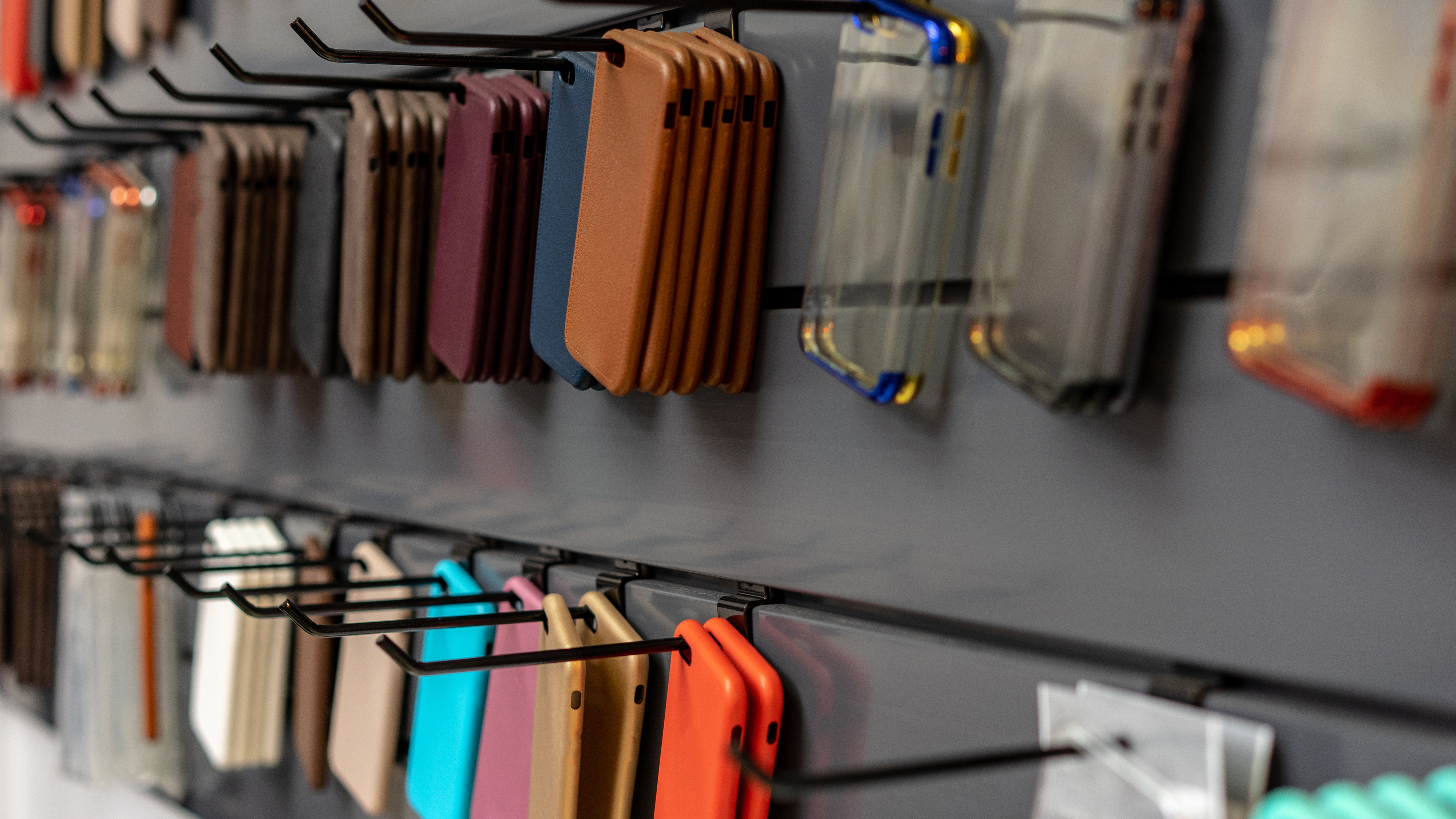 A display wall filled with various smartphone cases of different styles, including clear, leather, and colorful designs