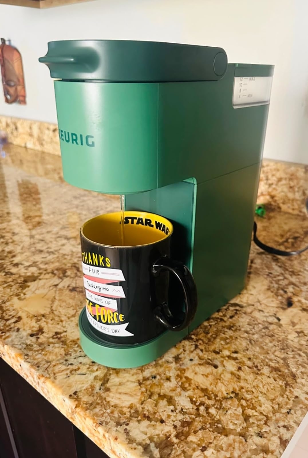 Green Keurig coffee maker on a kitchen counter with "Star Wars" mug featuring "Thanks for teaching me the ways of the Force" text