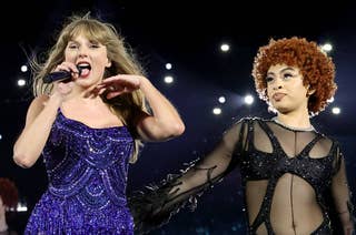 Taylor Swift in a sparkling dress and Ice Spice in a black, sequined outfit performing on stage