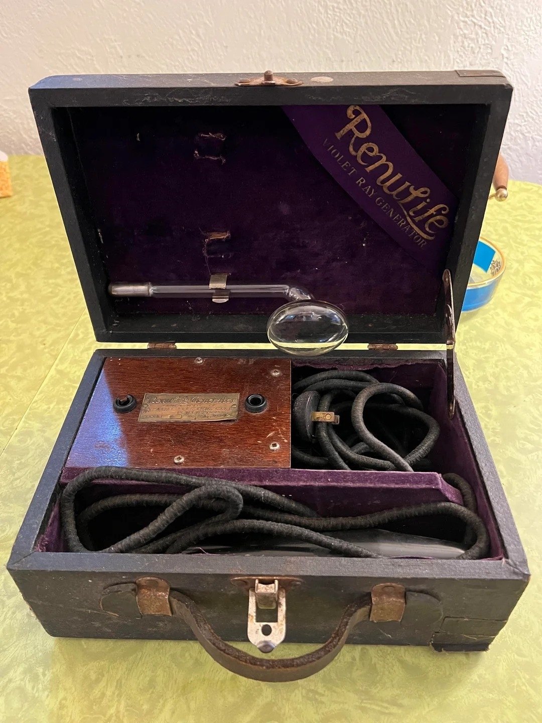 An open vintage medical device case labeled "Renulife" showing internal components including a glass electrode, wires, and a control panel