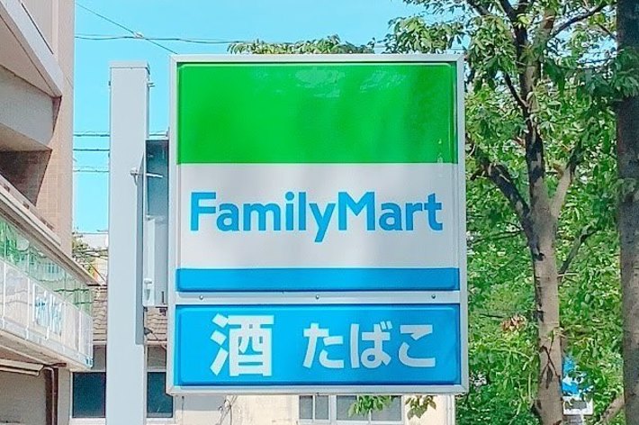 FamilyMartの看板。「酒」「たばこ」の文字が表示されています。背景には木々と建物が見えます。