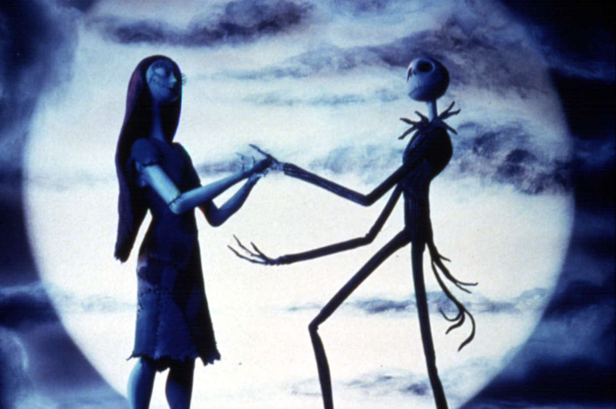 Sally and Jack Skellington from The Nightmare Before Christmas hold hands against a full moon backdrop in a touching moment