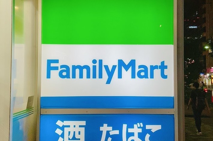 ファミリーマートの看板、「酒 たばこ」の文字が表示されている。