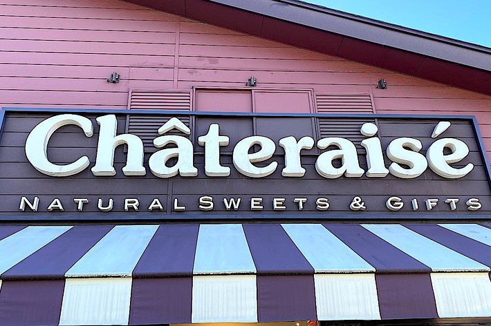 Storefront signage reads “Châteraisé Natural Sweets & Gifts” above striped canopy