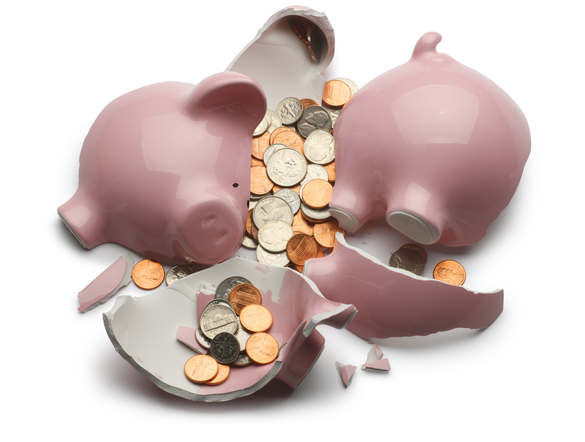 A shattered pink piggy bank with assorted coins, including pennies, nickels, dimes, and quarters, spilling out