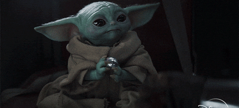 Grogu, also known as The Child or Baby Yoda, from the Disney+ series The Mandalorian, holding a shiny metal object with both hands