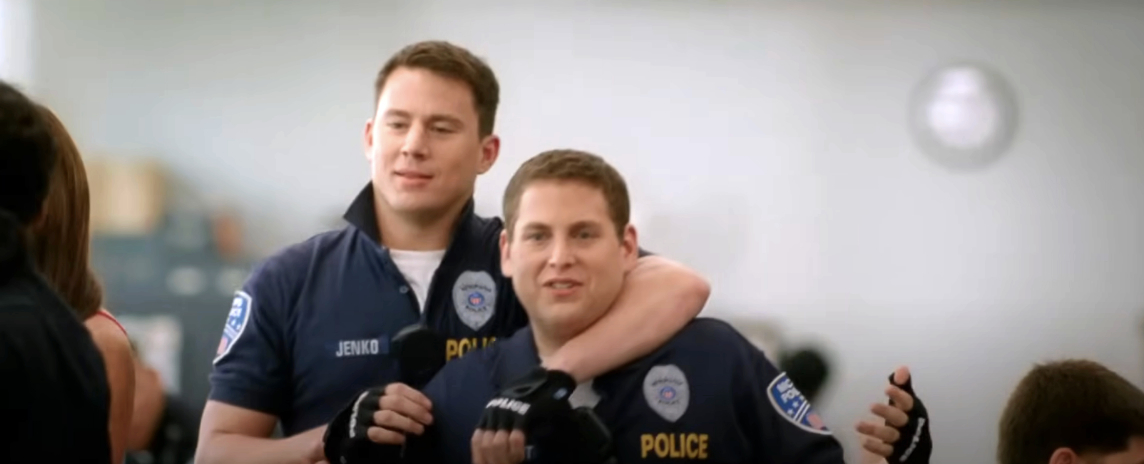 Channing Tatum and Jonah Hill dressed as police officers, with Tatum playfully putting his arm around Hill's neck