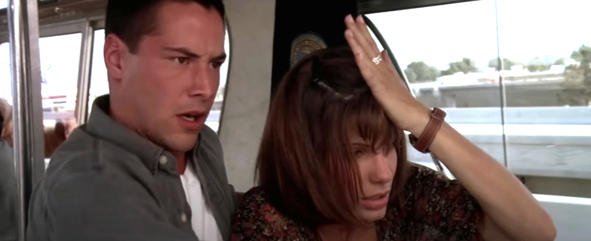 Keanu Reeves and Sandra Bullock look concerned on a bus in a scene from the movie "Speed."