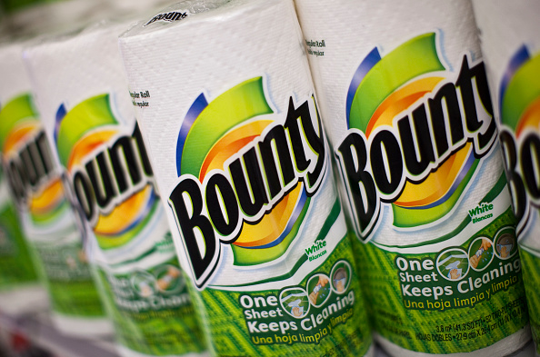 Several rolls of Bounty paper towels are lined up on a store shelf. The packaging highlights &quot;One Sheet Keeps Cleaning.&quot;