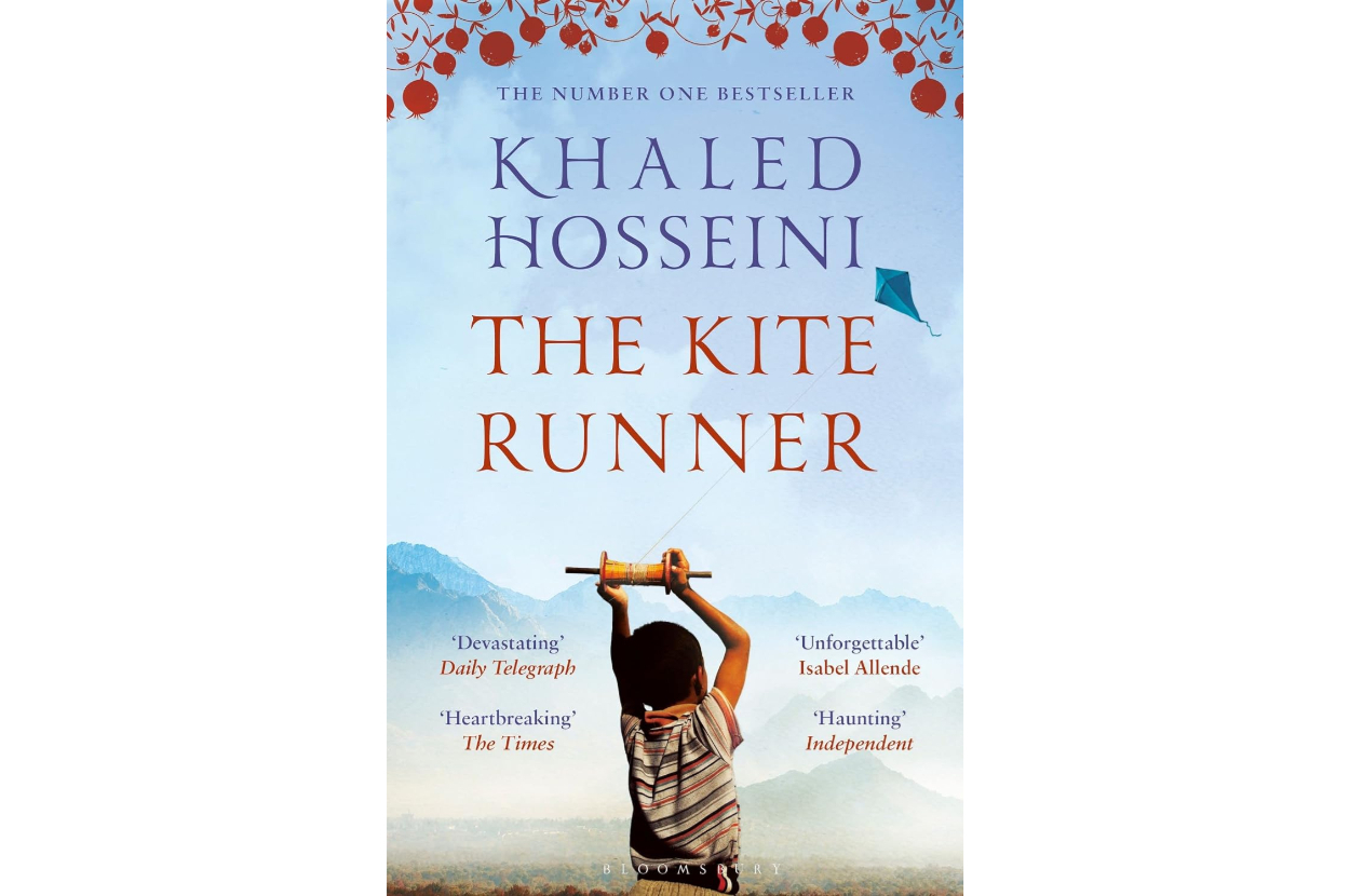 Book cover of &quot;The Kite Runner&quot; by Khaled Hosseini, featuring a child holding a kite handle with a mountainous backdrop and review quotes
