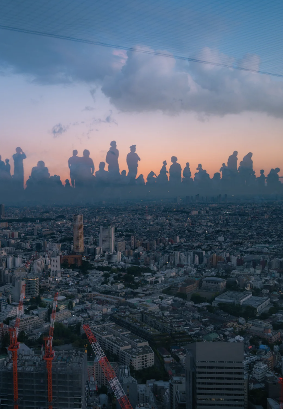 Cityscape at sunset with silhouetted figures reflected in the sky