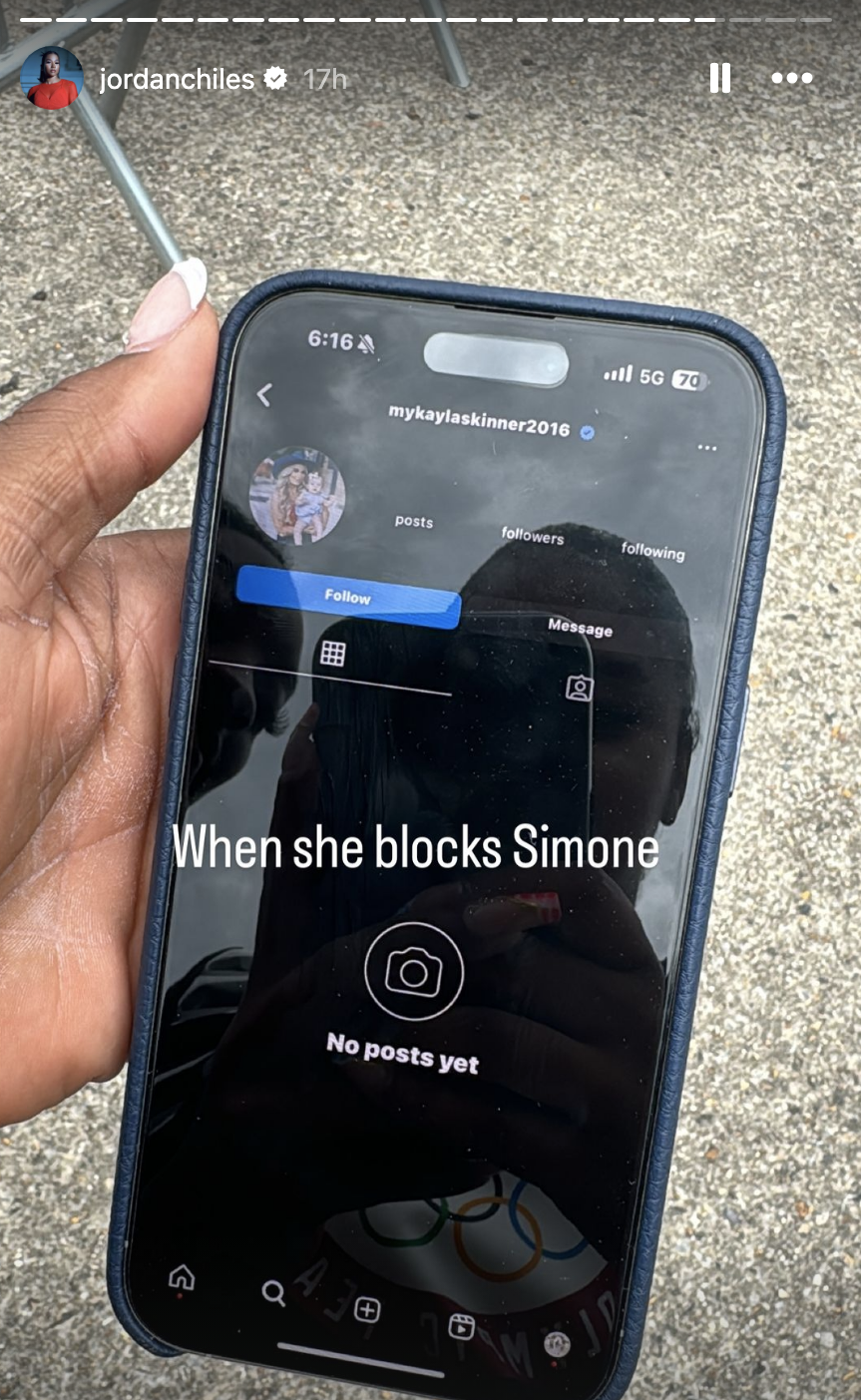 Jordan Chiles holds a phone showing an Instagram profile screen of &quot;mykaylaskinner2016&quot; with text overlay reading &quot;When she blocks Simone&quot;