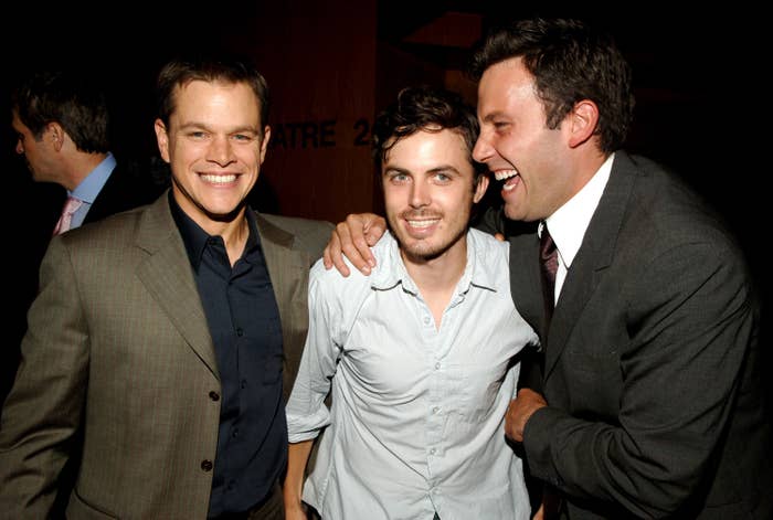 Matt Damon, Casey Affleck, and Ben Affleck smile and pose together at an event, dressed in suits