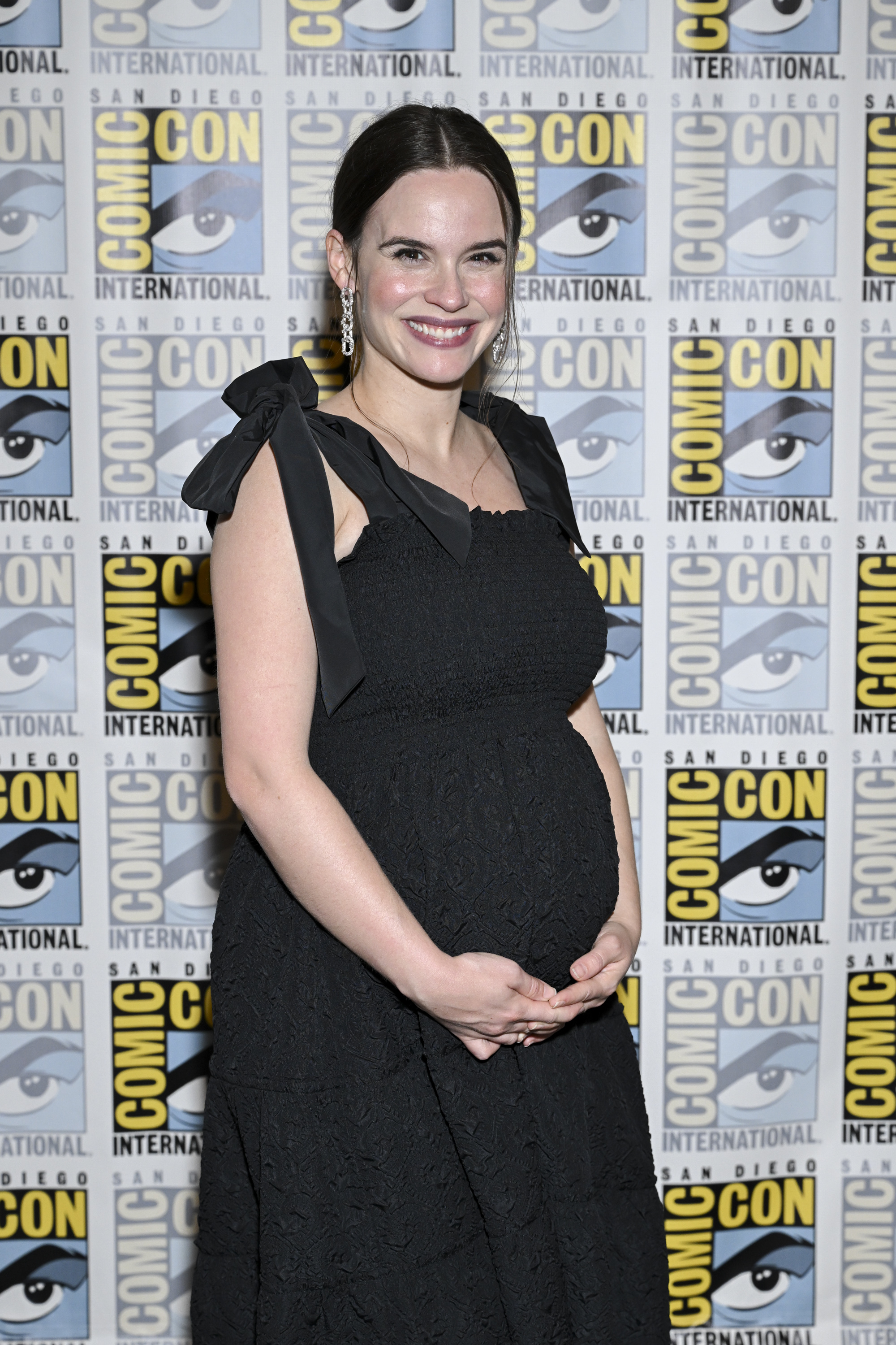 Closeup of Ema Horvath cradling her baby bump
