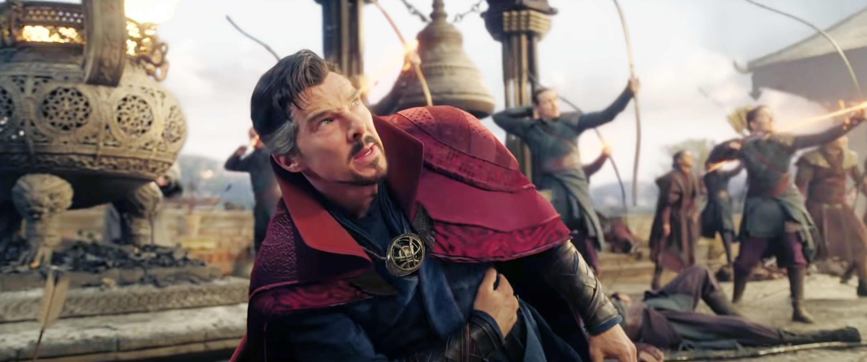 Benedict Cumberbatch as Doctor Strange wounded and fighting in a cinematic battle scene with archers in the background