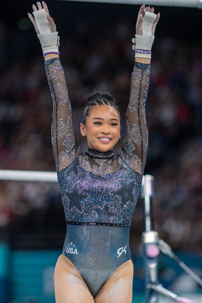 Gymnast Suni Lee performs a routine, wearing a sparkly leotard with USA lettering, in a gymnastics competition