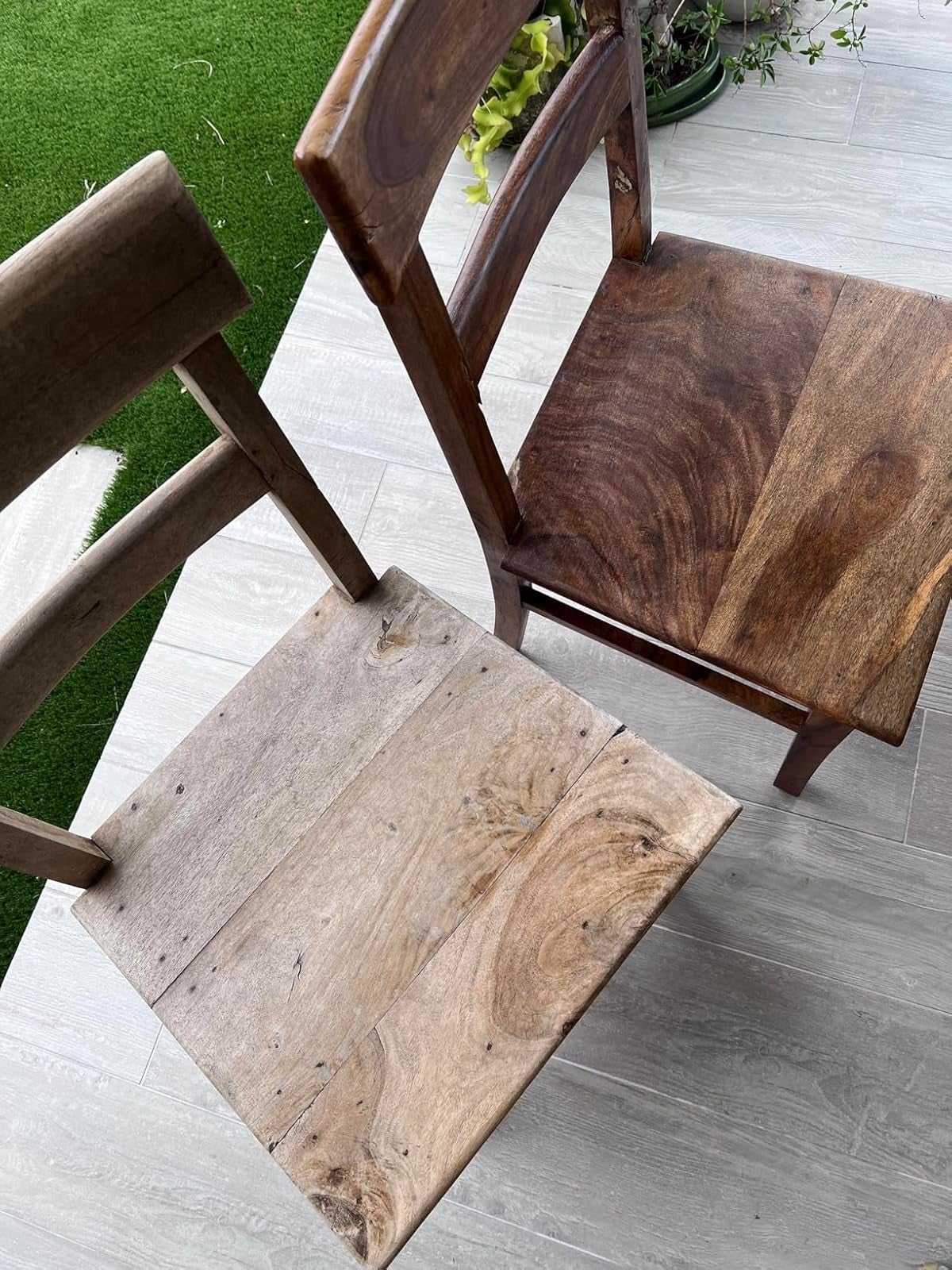 a reviewer's woody  seat  with a unsocial   spot   plan  resembling a rustic plank of wood, placed connected  a grey tiled level  adjacent  to a railing