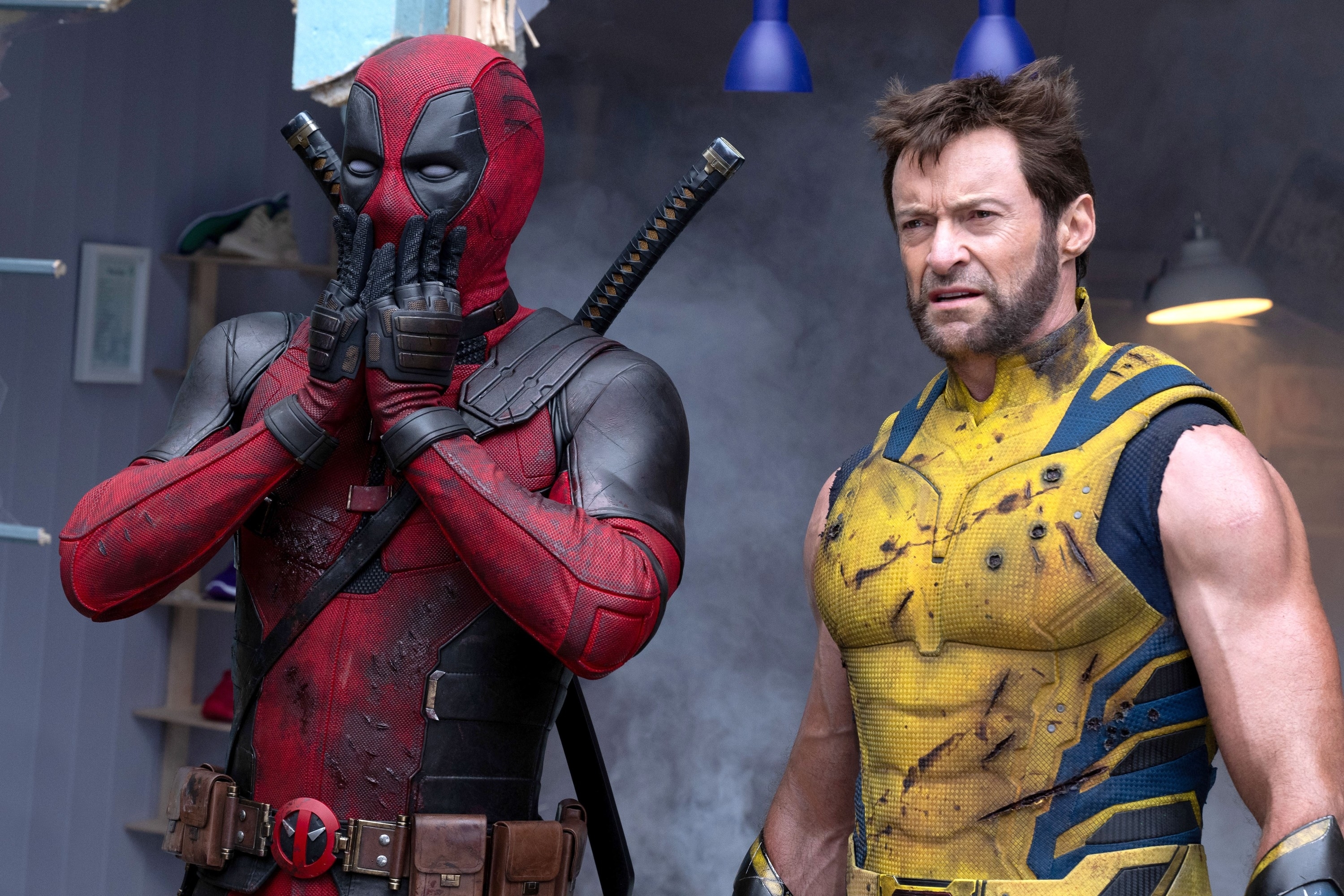 Deadpool (Ryan Reynolds) and Wolverine (Hugh Jackman) in character, standing together. Deadpool has his hands on his face, and Wolverine looks determined