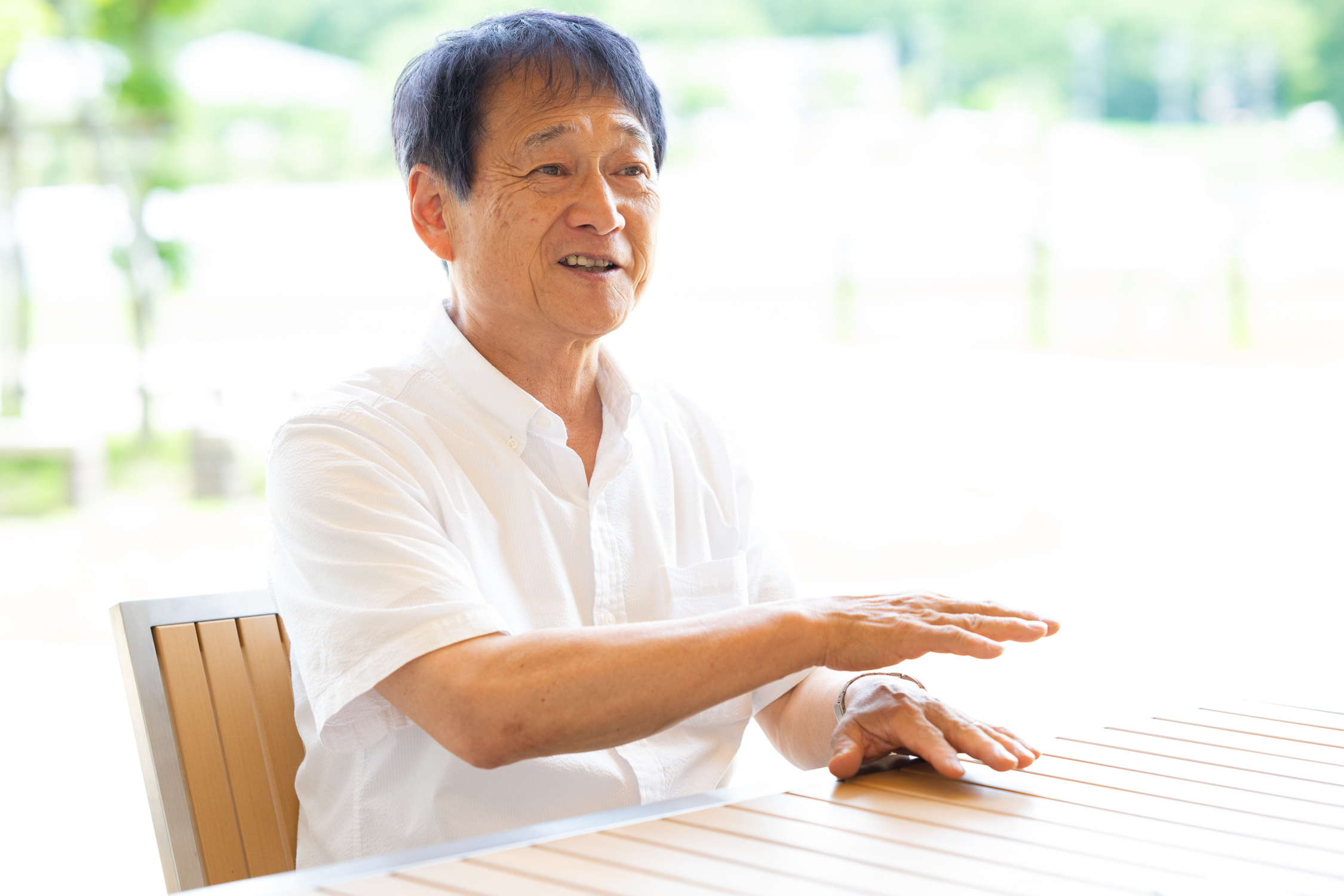 男性がテーブルに座って話している。