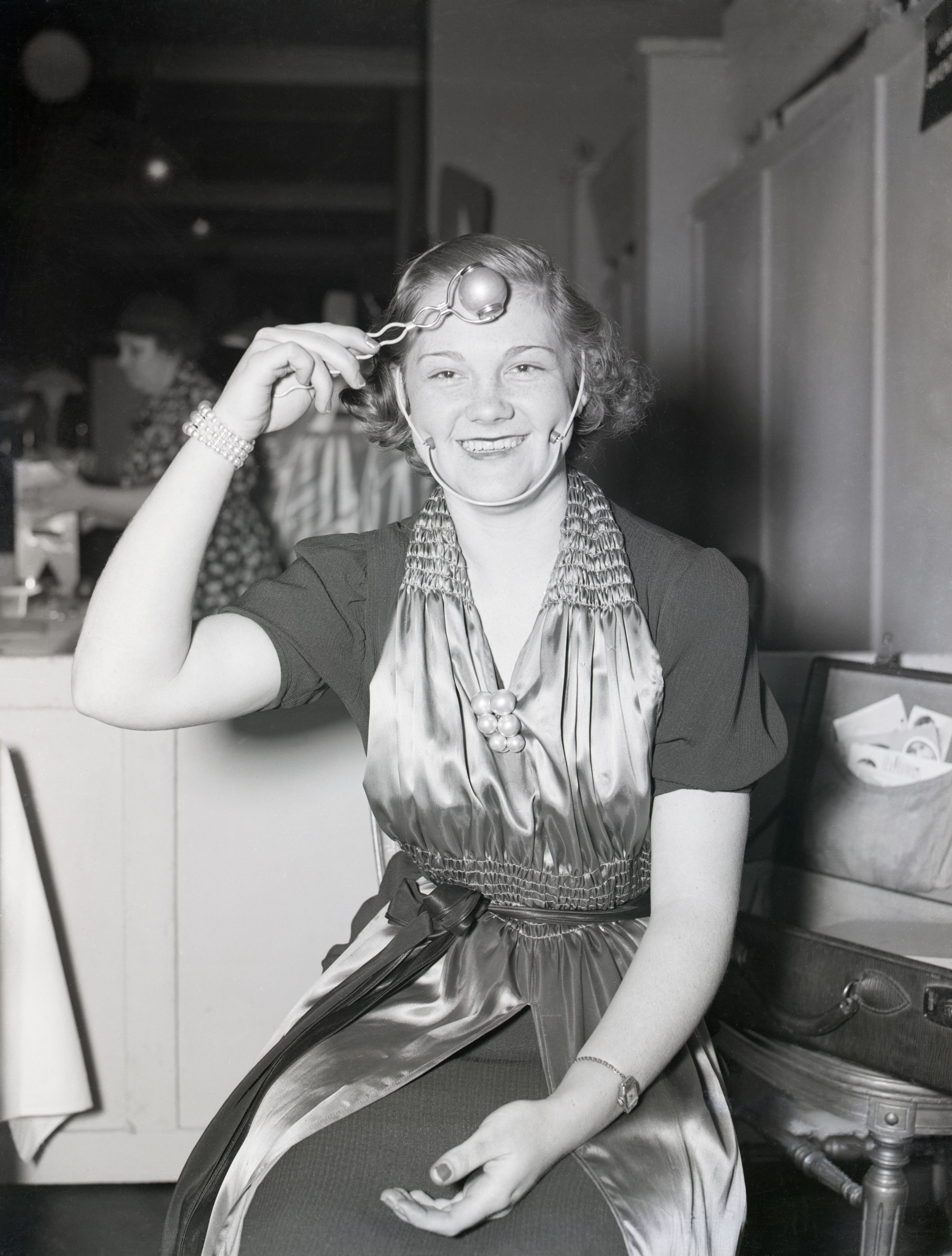 A young woman demonstrates a "dimple" machine at the Inventor's Congress in Chicago.